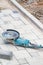 A worn-out angle grinder with diamond discs lies on paving slabs in front of the workplace. Vertical image, copy space