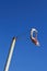 Worn out windsock against blue sky