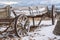 A worn out wooden wagon with rusty wheels and powdery snow viewed in winter