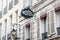 The worn period sign of an hotel and a vintage street light fixed to an old building in Paris