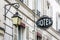 The worn period sign of an hotel and a vintage street light fixed to an old building in Paris