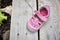 Worn pink children shoe on wooden plank background