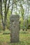 A worn sandstone grave marker in the shade on a very bright day. There is no text visible on the stone, but there is