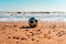 Worn soccer ball on the sandy beach after the game, the ball is dirty with sand on the shore of the beach with the sea
