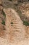 Worn steps of stone staircase are cut down by tourist along popular tourist route. Trail goes up stone stairs. Stone staircase in