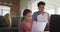 Worried biracial couple sitting on sofa in living room, using laptop