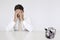 Worried businessman at table with trapped piggy bank representing financial difficulties