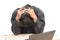 Worried businessman . a young man sits at his Desk and holds his hands on his head