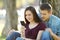 Worried couple seeing content in a smart phone