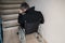 Worried disabled man in front of staircase