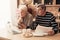 Worried Elderly Couple Using Laptop In Kitchen, Checking Domestic Finances