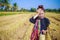 Worried farmer woman with tiffin carrier in rice field