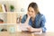 Worried female reading a letter on a table at home