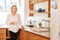 Worried looking senior woman standing in her kitchen