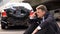 Worried man talking on phone outdoors broken auto background, traffic collision