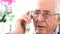 Worried Senior Man Answering Telephone At Home