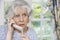 Worried Senior Woman Answering Telephone At Home