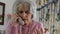 Worried Senior Woman Answering Telephone At Home