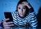 Worried unhappy young woman suffering from cyberbullying and harassment online by mobile phone