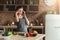 Worried woman talking on phone in home kitchen