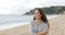 Worried woman walking alone on the beach