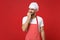 Worried young bearded male chef cook or baker man in striped apron white t-shirt toque chefs hat posing isolated on red