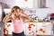 Worried Young Woman Standing In Dirty Kitchen