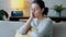 Worried young woman thinking while sitting on sofa in the living room at home.