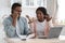 Worry Black Couple Sitting In Kitchen With Financial Papers, Calling To Bank