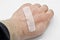 Wounded hand wrapped with band-aid. A medical band-aid for small wounds.