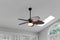 Woven Elegant Ceiling Fan Light Fixture in Sunroom Interior with White Ceiling and Arch Window