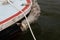 Woven and wrapped rope boat bumper on a sailboat in water, maritime details