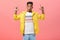Wow awesome copy sace look. Portrait of imressed enthusiastic handsome dark-skinned guy in yellow poplin jacket folding