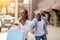 Wow, come with me to boutique. Happy woman with multicolored bags leads man to shopping