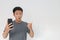 Wow face of Your Asian man shocked what he see in the smartphone on  grey background