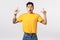 Wow incredible, check this out. Astonished and amused speechless shocked asian handsome young man in yellow t-shirt