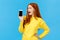 Wow look at this app. Amused and wondered, excited redhead girl looking at smartphone display, showing mobile screen