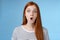 Wow omg fascinating. Impressed surprised amused good-looking redhead girl folding lips astonished wide eyes stunned