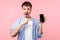 Wow, what a gadget! Portrait of amazed mobile user, brown-haired man pointing at smartphone. isolated on pink background