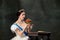 Wow. Young beautiful woman, royal person, queen or princess in white medieval outfit tasting burger on dark background