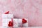 Wrapped boxes with presents and hearts  against pink  textured  wall