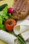 Wrapped empty tortillas on a table with tomato, lettuce and ham