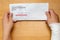 Wrapped hand holding envelope with workers compensation claim and result of approved removeable words with clipping path