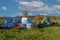 Wrapped straw bales. The bales are stacked in a meadow and covered with a tarpaulin against the rain