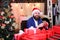 Wrapping gifts add festive details. Man bearded santa prepared christmas gifts. Businessman near christmas tree wrapping