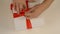 Wrapping white gift box. Caucasian mans hands packing gift box. Mens hands tie a red ribbon around a white cardboard box