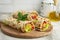 Wraps with a soft flatbread rolled around a filling with vegetables and cheese,