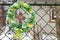 Wreath with a cross and the image of the Mother of God on the fence at home in the Carpathian Mountains