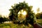 Wreath of different flowers on a background of blue sky. flowers wreath in women hands in the evening sunset