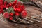 Wreath with lotus flower and red berries. Christmas winter frame on dark wooden background. Red elements